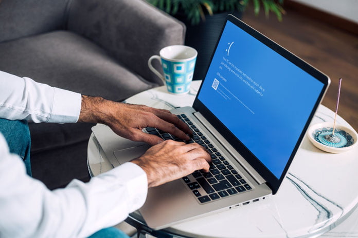 Windows 10 Media Creation Tool - Mann sitzt am Windows 10 Rechner und hat einen Bluescreen Fehler